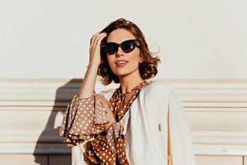Lovely woman in vintage outfit expressing interest. Outdoor shot of glamorous happy girl in...