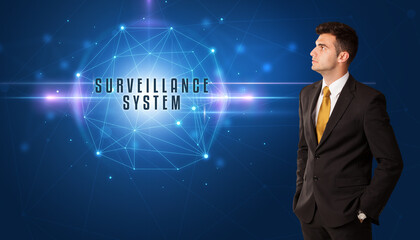 Businessman thinking about security solutions with SURVEILLANCE SYSTEM inscription