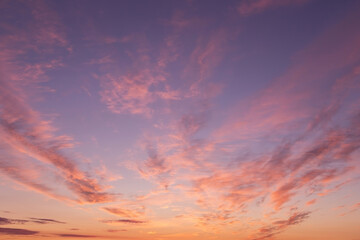 Dramatic soft sunrise, sunset. Beautiful pink violet orange clouds against blue sky background...