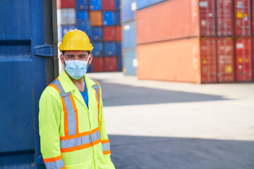 portrait of foreman in yellow suite and mask at cargo container site