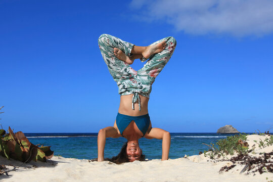 Young woman doing yoga on the beach