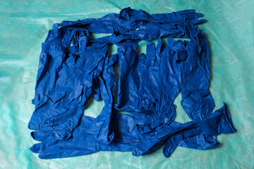 Blue gloves piled on green sanitary cloth.  
Hand and arm protection.