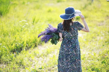 Pregnant girl in a field with lupines
