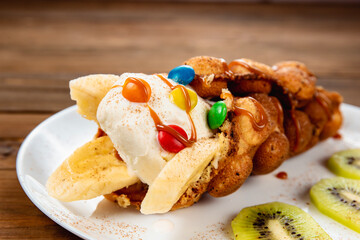 Ice cream ice cream in a waffle cone with sweets and fruit syrup