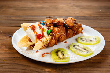 Ice cream ice cream in a waffle cone with sweets and fruit syrup