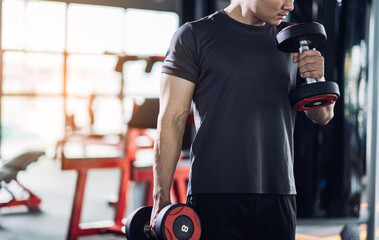 Sportsman doing exercises with dumbbells, strong male keeping fit workout.