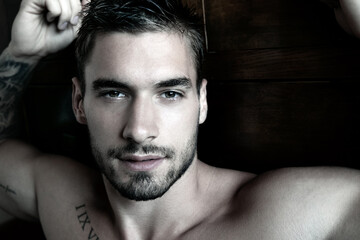 Portrait of good looking shirtless man looking at camera