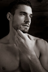Portrait of enigmatic handsome man with beard looking away from camera