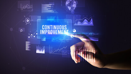 Hand touching CONTINUOUS IMPROVEMENT inscription, new business technology concept