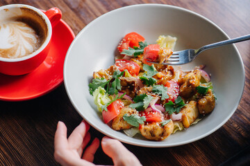 Exquisite salad dish in a bowl, raw and fried vegetables mixed together.
