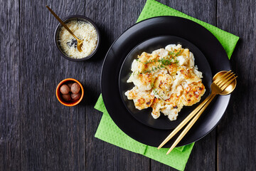 Creamy cauliflower cheese on a plate, copy space