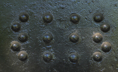Detail of an old surface with exfoliated paint and rivets on military equipment. Military background. High quality photo