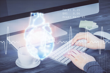 Heart drawing with man working on computer on background. Medical concept. Double exposure.