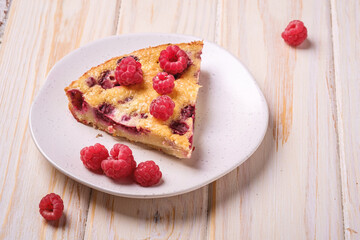 Sweet tasty pie slice with jellied and fresh raspberry fruits in plate, wooden table background, angle view close up