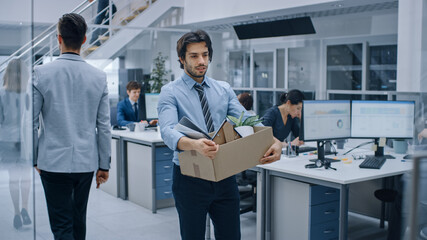 Sad Fired / Let Go Office Worker Packs His Belongings into Cardboard Box and Leaves Office....