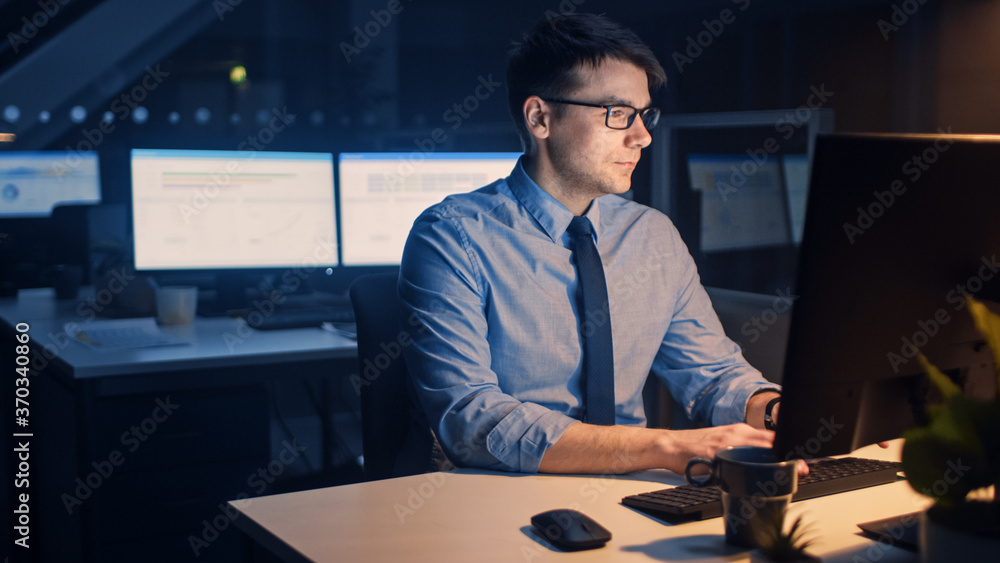 Poster portrait of ambitious and confident businessman uses desktop computer, typing on a keyboard, monitor