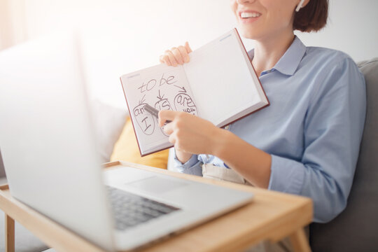Online English training during pandemic. Woman teacher teaches children and students video call chat, explains rules of grammar language