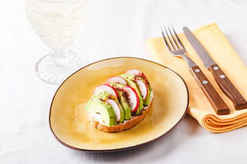 toasted ciabatta with pate of avocado and fresh radish, close-up, horizontal