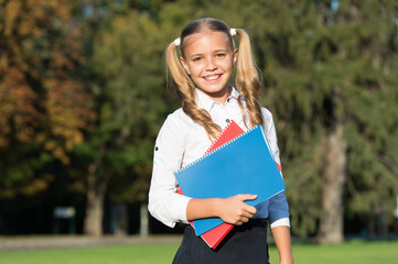 Excellent student girl study with school book outdoors, free courses concept