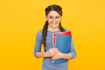 Read books to inspire creativity in you. Happy child hold books. Little bookworm yellow background....