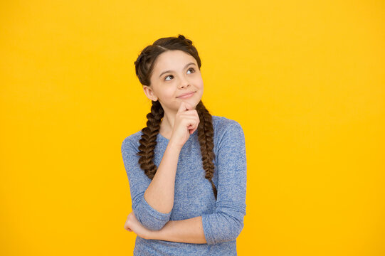 thoughtful girl with braids. adorable daydreaming kid. think about future. Portrait of pensive teen girl on yellow background. Let me think. Doubt concept. Doubtful child remembering something