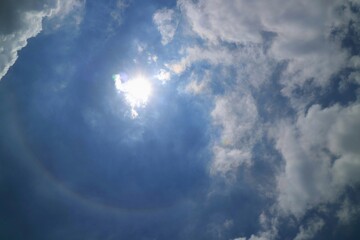 Beautiful sun halo with blue sky and big white cloud in summer time, soft focus. Nature background concept.