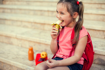 Pupil having a snack sitting on a stairs outdoor. Back to school.