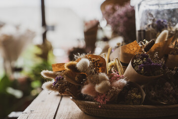 Obraz na płótnie Canvas Rabbit tail grass flower bunch in tray on woodden table in flower shop, Vintage tone