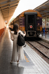 Women tourists are taking pictures at the train station