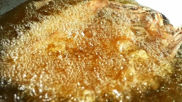 Close up Cooking Fried fish in a boiling oil in frying pan.