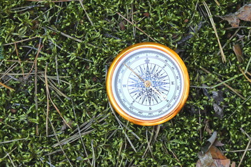 round compass on background of summer grass as symbol of tourism with compass, travel with compass...