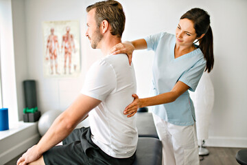 physiotherapist doing treatment with patient in bright office - obrazy, fototapety, plakaty