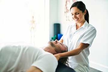 physiotherapist doing neck treatment with patient in bright office