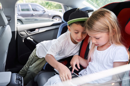 Happy Kids Playing On Tablet In Car