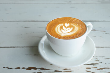 latte coffee with heart in white cup on grunge wooden table