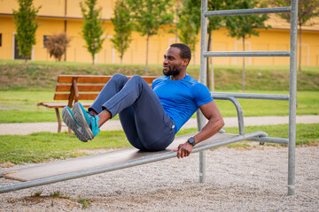 Fitness afro american boy doing situps outdoor - Handsome african man doing stretching exercises at...