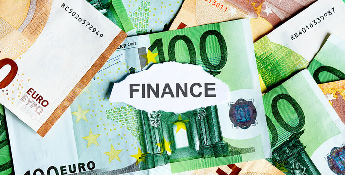 Focus on the word FINANCE on piece of torn white paper with EUROS currency as a background.