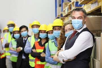 CEO and the rest of the engineering team standing together in the factory wearing facial mask during new normal and social distancing policy