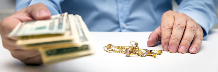 Buying gold jewelry, us dollars and hand of a businessman, panorama
