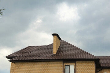 roof with new brown roofing tiles on residential property. banner on  roof for roofers. concept for...