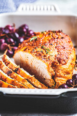Roasted turkey breast with grapes in black dish, close-up.