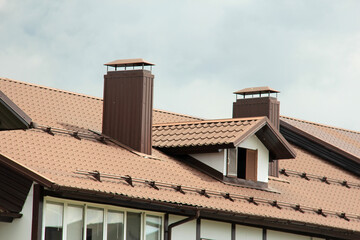 roof with new brown roofing tiles on residential property. banner on  roof for roofers. concept for...