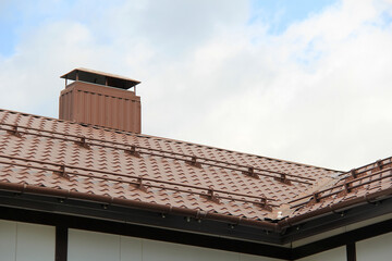 roof with new brown roofing tiles on residential property. banner on  roof for roofers. concept for...
