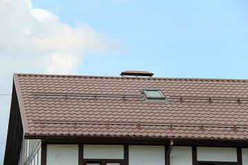 roof with new brown roofing tiles on residential property. banner on  roof for roofers. concept for...