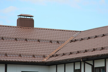 roof with new brown roofing tiles on residential property. banner on  roof for roofers. concept for...