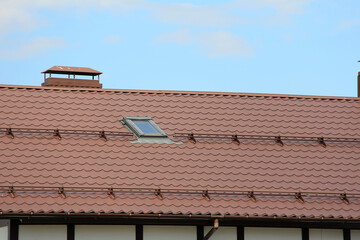 roof with new brown roofing tiles on residential property. banner on  roof for roofers. concept for...