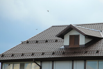 icon roof with new brown roofing tiles on residential property. banner on  roof for roofers....
