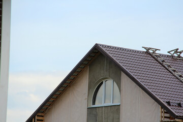 icon roof with new brown roofing tiles on residential property. banner on  roof for roofers....