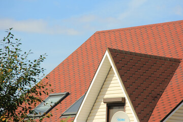 icon roof with new brown roofing tiles on residential property. banner on  roof for roofers....