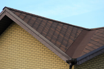 icon roof with new brown roofing tiles on residential property. banner on  roof for roofers....